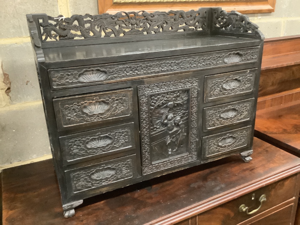 An Edwardian chinoiserie inspired ebonised oak table top cabinet, with cupboard and seven drawers, width 66cm